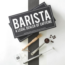 Load image into Gallery viewer, Barista Essentials gift box featuring  coffee accessories: frother, brush, and bag clip laying on a table with an espresso cup
